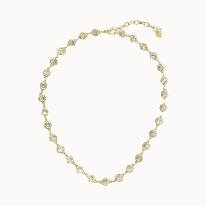 Gold necklace with clear stones on a white background
