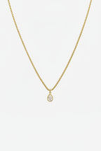 Gold necklace with a teardrop pendant on a white background