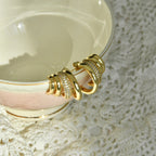 Gold bracelet on a white ceramic plate with lace background