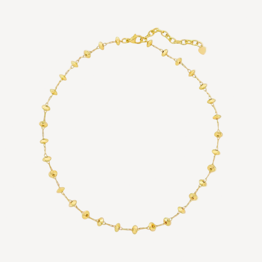 Gold beaded necklace on a white background