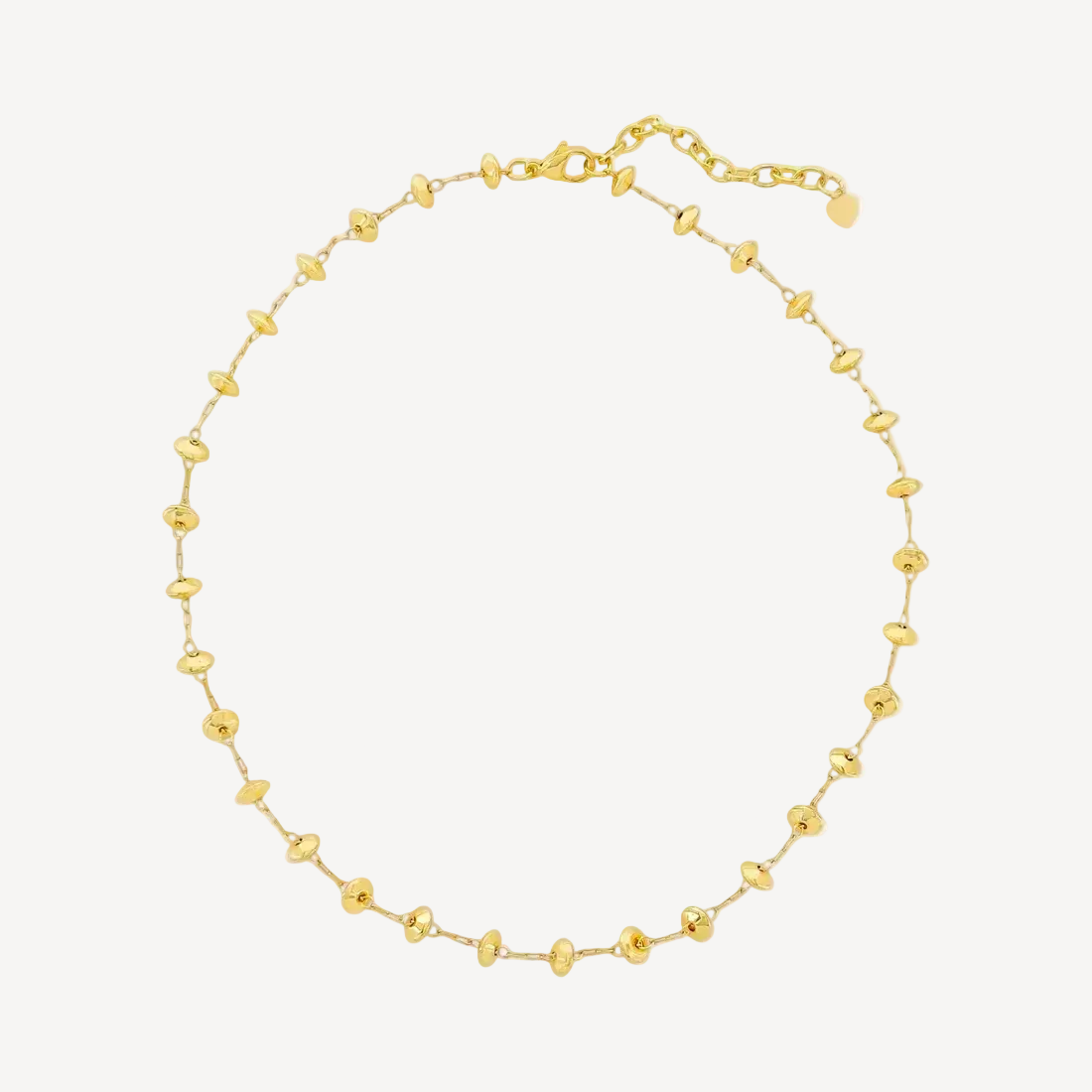 Gold beaded necklace on a white background